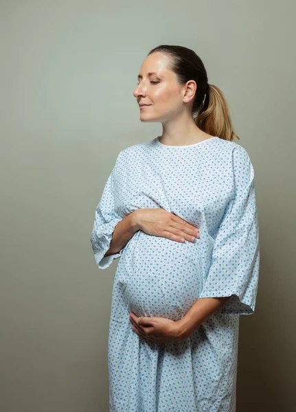 Young Pregnant Woman Hospital Robe Pose Holding Big Belly Tired — Stockfoto