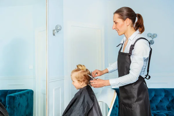 Profile Portrait Though Mirror Little Blond Boy While Professional Stylist — Stockfoto