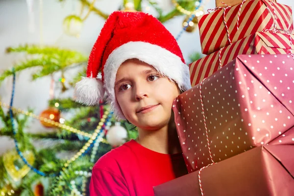 Close Portrait Boy Standing Huge Stack Presents Santa Hat Christmas — Stockfoto