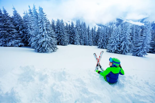 Skier Chłopiec Siedzieć Śniegu Nad Śnieżnym Lesie Jodły Ciężkich Opadów — Zdjęcie stockowe
