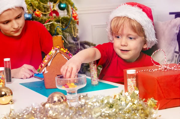 Happy Little Toddler Boy Takes Candy Put Gingerbread House Decorating — Stock Photo, Image