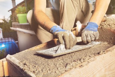 Malayla çalışan bir adamın yakın çekimi evde beton merdiven yapar.