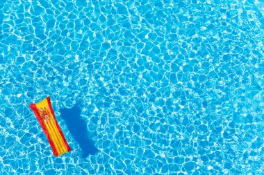 İspanya 'nın şişirilebilir şiltesi havuz üzerinde yüzen mavi su yüzeyinde fotokopi alanı ile bayrak renkleri