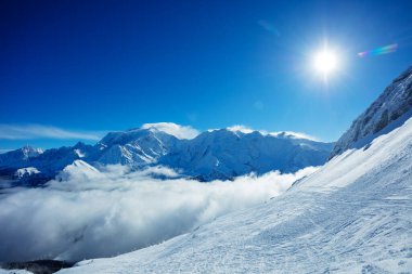 Valley in French Alps mountains Mont Blanc massif with thick clouds bellow and bright sun above