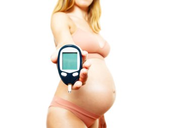 Hamile kadın, kan şekeri testi yapan, arka planda büyük göbekli bir diyabet hastası.