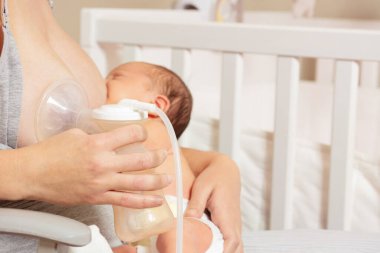 Breast pump close up and woman breastfeed baby on the background
