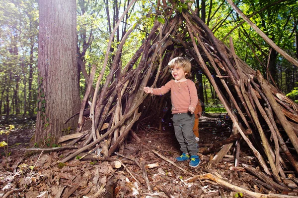 Cute Little Blond Boy Play Soap Bubbles Hut Branches Forest — 图库照片