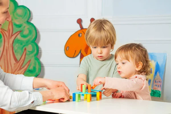Mother Two Little Small Children Build Tower Color Blocks Table — Fotografia de Stock