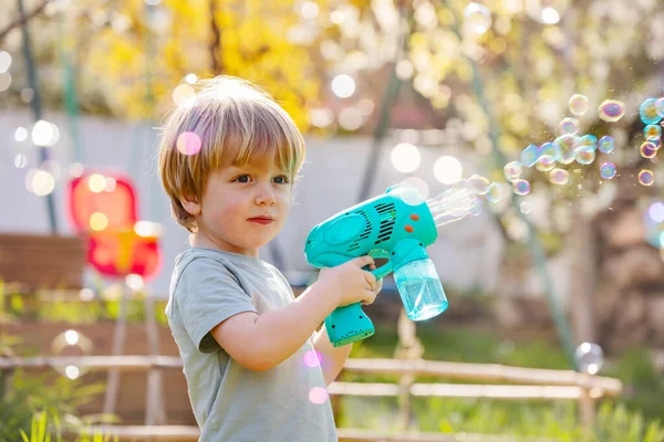 Handsome Little Boy Play Soap Bubbles Gun Backyard Garden — Stock fotografie