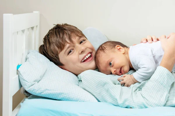 Close Portrait Positive Happy Little Boy Lay Bed Hugging Newborn — Stock fotografie