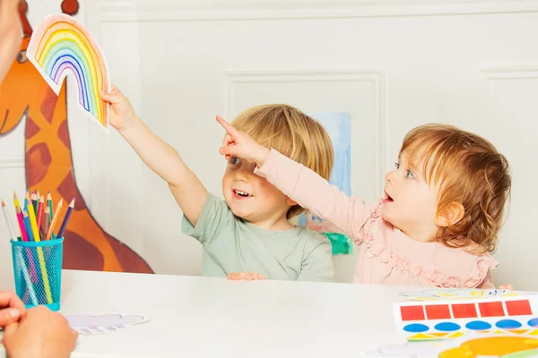Два Мальчика Маленькая Девочка Указывают Радужную Карту Сидящую Классе Развития — стоковое фото