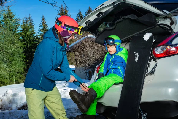Anya Segít Fiatal Fiúnak Hogy Felvegye Snowboard Csizmát Parkolóban Csomagtartóban — Stock Fotó