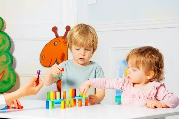 Duas Crianças Menino Loiro Menina Construir Com Ajuda Torre Adulta — Fotografia de Stock