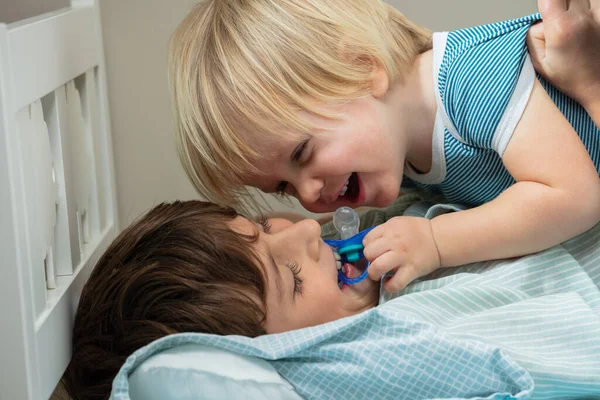 Little Blond Boy His Brother Have Fun Bed Playing Pacifier — 스톡 사진