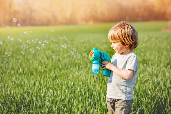 Little Blond Boy Play Soap Bubbles Standing Together Spring Green — Stock fotografie
