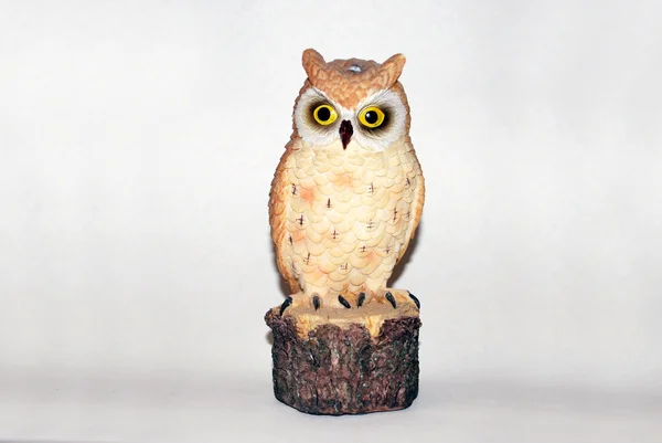 beyaz zemin üzerinde bir baykuş heykeli