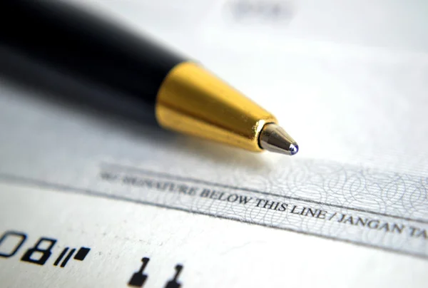 Fechar o cheque com uma caneta — Fotografia de Stock