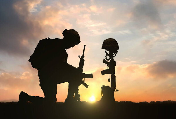 3D illustration of a military man kneeling in front of Fallen Soldier grave during sunset