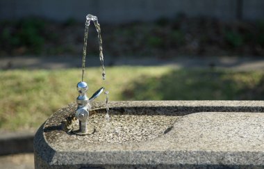 Güneşli bir günde parkta musluk.                               