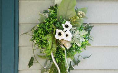 Bir evin duvarında asılı çiçek süslemeleri.                               