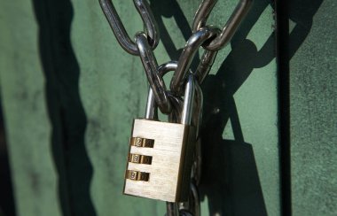 Dış kapının zincirinde asılı olan çevirme kilidi                               