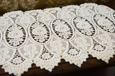 Örgü beyaz renkte ve masanın üzerinde desen var.                               