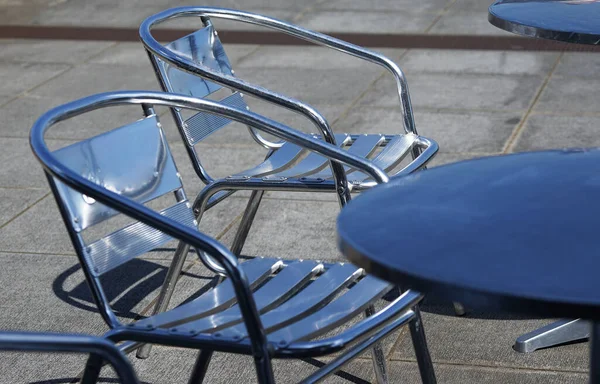 Parlak metal sandalyeler ve bahçede bir masa                               