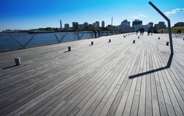 Bir liman şehrinin liman meydanında mavi gökyüzü ve ahşap döşeme                               