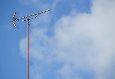 Güneşli bir günde binanın çatısında TV anteni                               