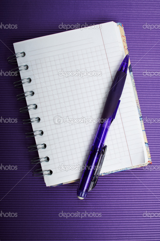 The ruled notepad with a pencil on a violet corrugated backgroun