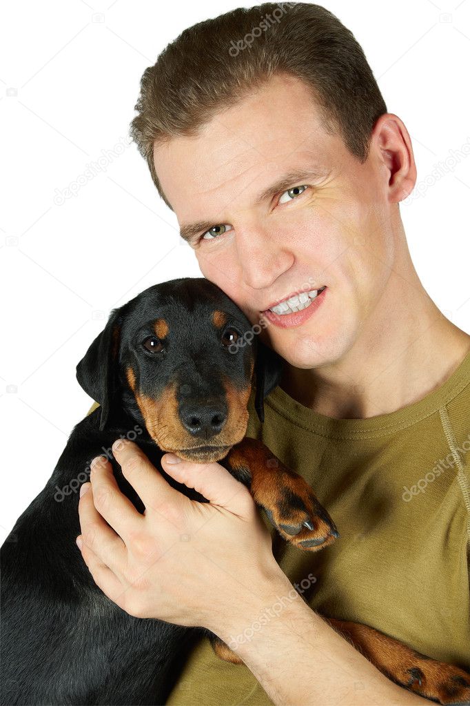 The man in a green t-shirt embraces a puppy of a Jagdterrier, a