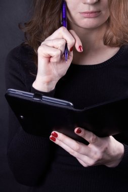 Siyah kazaklı düşünceli defterinde, m yapıyor görünüyor