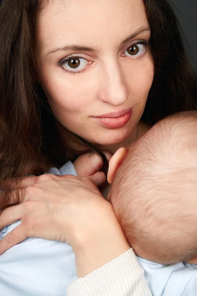 Young mother embraces the child and looks in the camera — Stock Photo, Image