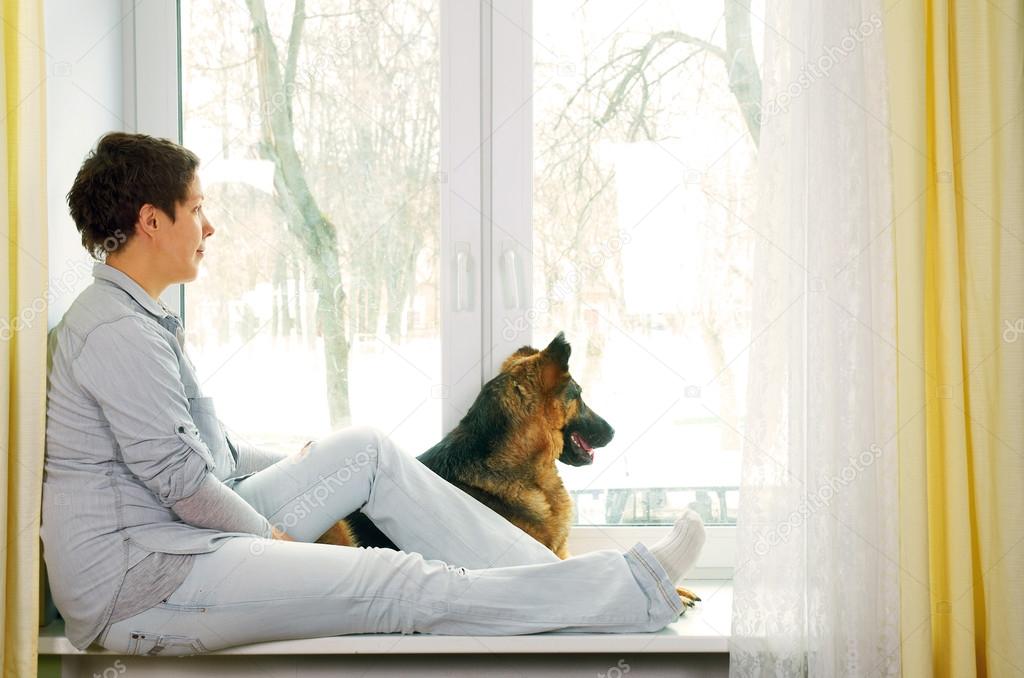 The girl with a short hairstyle in jeans clothes waits for someo