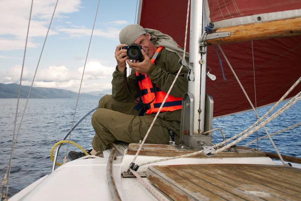 Yat burun üzerinde oturan gülümseyen adam fotoğrafları