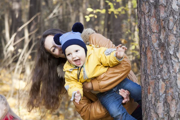 The laughing child on hands at mother who is jumping out because — Stock Photo, Image