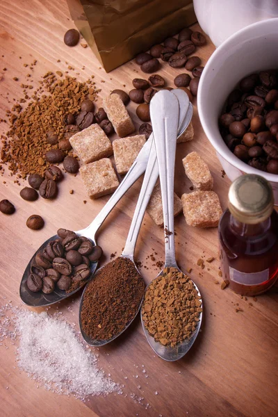 Teelöffel mit verschiedenen Kaffee liegen auf einem Tisch in einer Umgebung o — Stockfoto