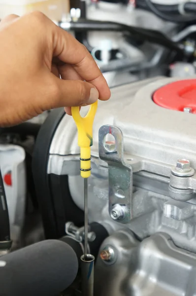 Uma pessoa que verifica o óleo do motor em seu carro — Fotografia de Stock