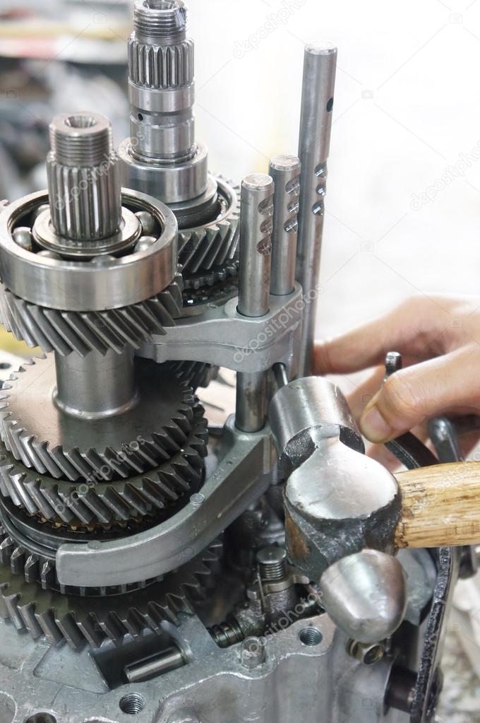 a pair of technician hand fixing the car gearbox