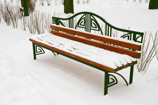 Χιόνι κάλυψε πάγκο στο χειμερινό πάρκο — Φωτογραφία Αρχείου