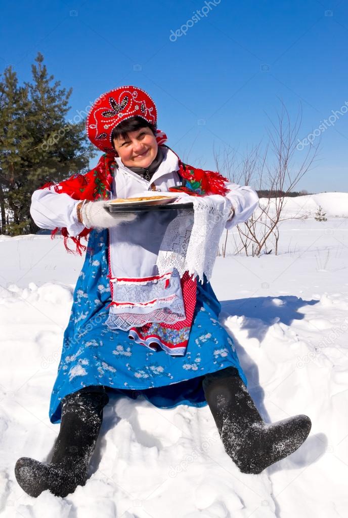 Russian woman in sundress with pancakes. Maslenitsa