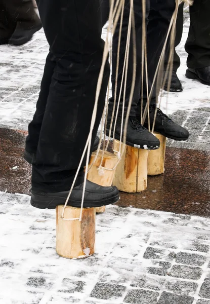 Entertainment on Shrove Tuesday: men's feet on wooden blocks with ropes — Stock Photo, Image