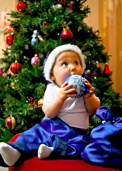Dziecko w niebieski garnitur santa Claus na tle drzew — Zdjęcie stockowe