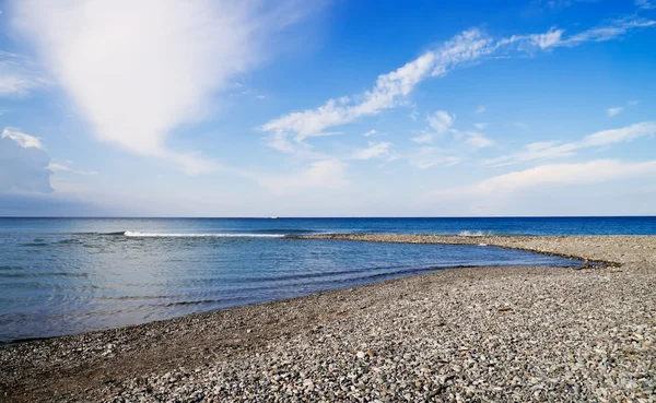 Kieselsteine einsame Küste blaues Meer — Stockfoto
