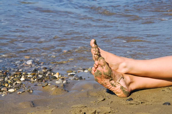 Frauenbeine auf dem Sand am Meer — Stockfoto