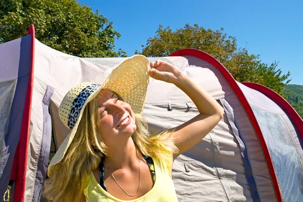 Blond meisje in stro hoed tegen de tent — Stockfoto