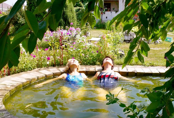 Zwei Frauen schwimmen im Pool ihres Ferienhauses — Stockfoto