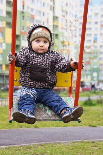 Bambino che oscilla su un'altalena nel cortile — Foto Stock