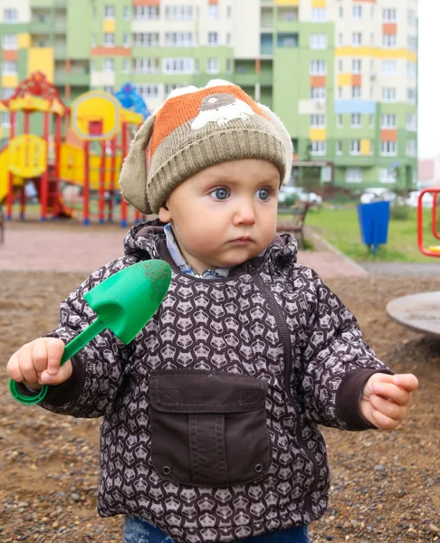 Ребенок с пылесосом для прогулки по детской площадке во дворе — стоковое фото