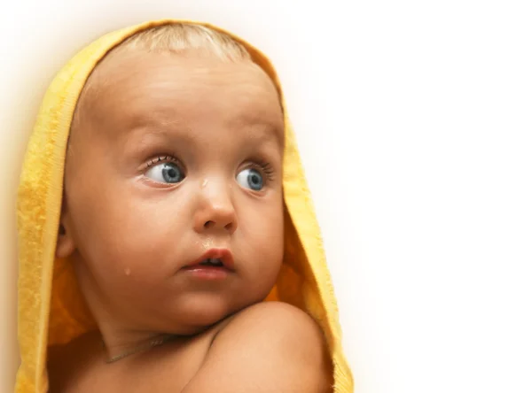 Portrait of sunburned baby after bathing under yellow towel — Stock Photo, Image
